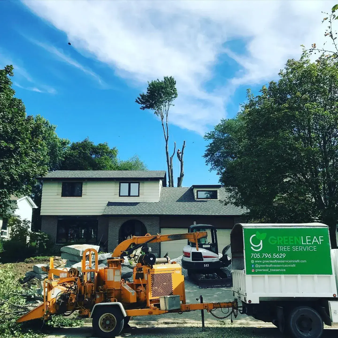 Green Leaf equipment and crew staged on a residential worksite